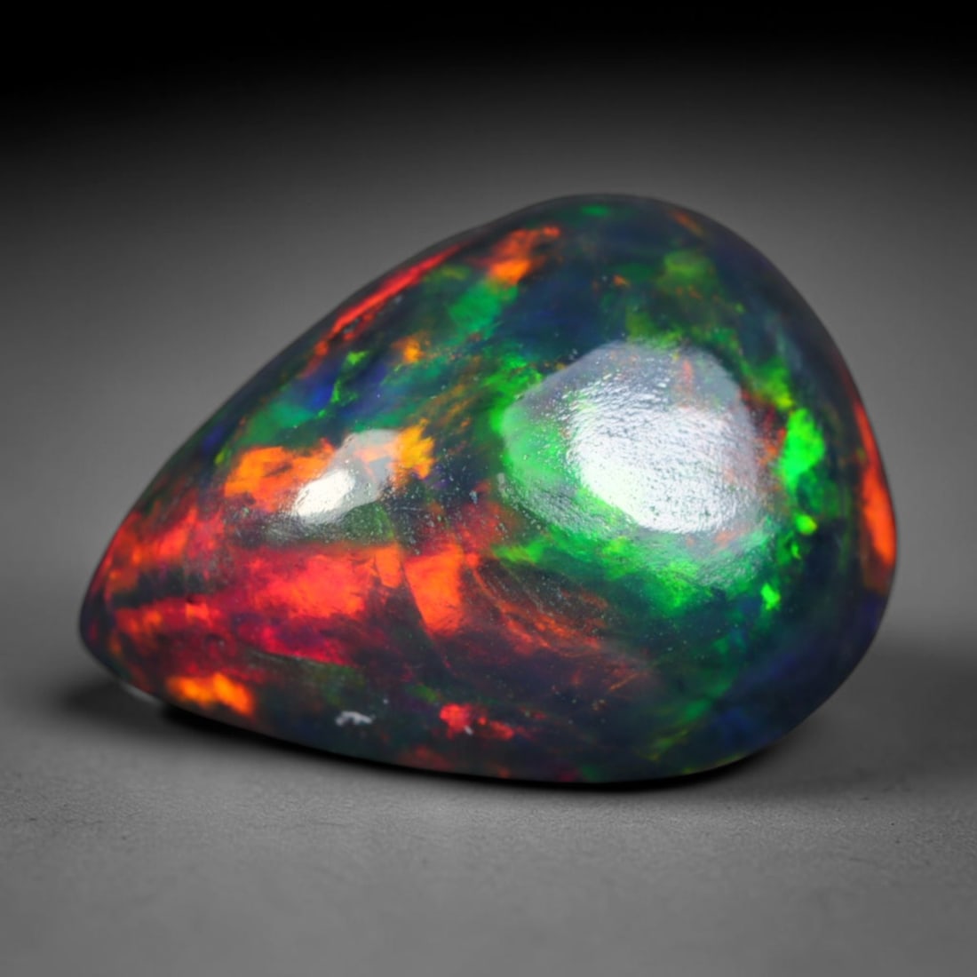 1.78ct Natural Ethiopian Welo Black Smoked Opal Cabochon Loose Gemstone, 55AK: This fully polished Ethiopian Welo opal features a dark smoked base with vivid, sweeping play-of-color shifting across its glossy dome surface, measured at 10.6x8.1x4.6mm. The black smoke treatment de