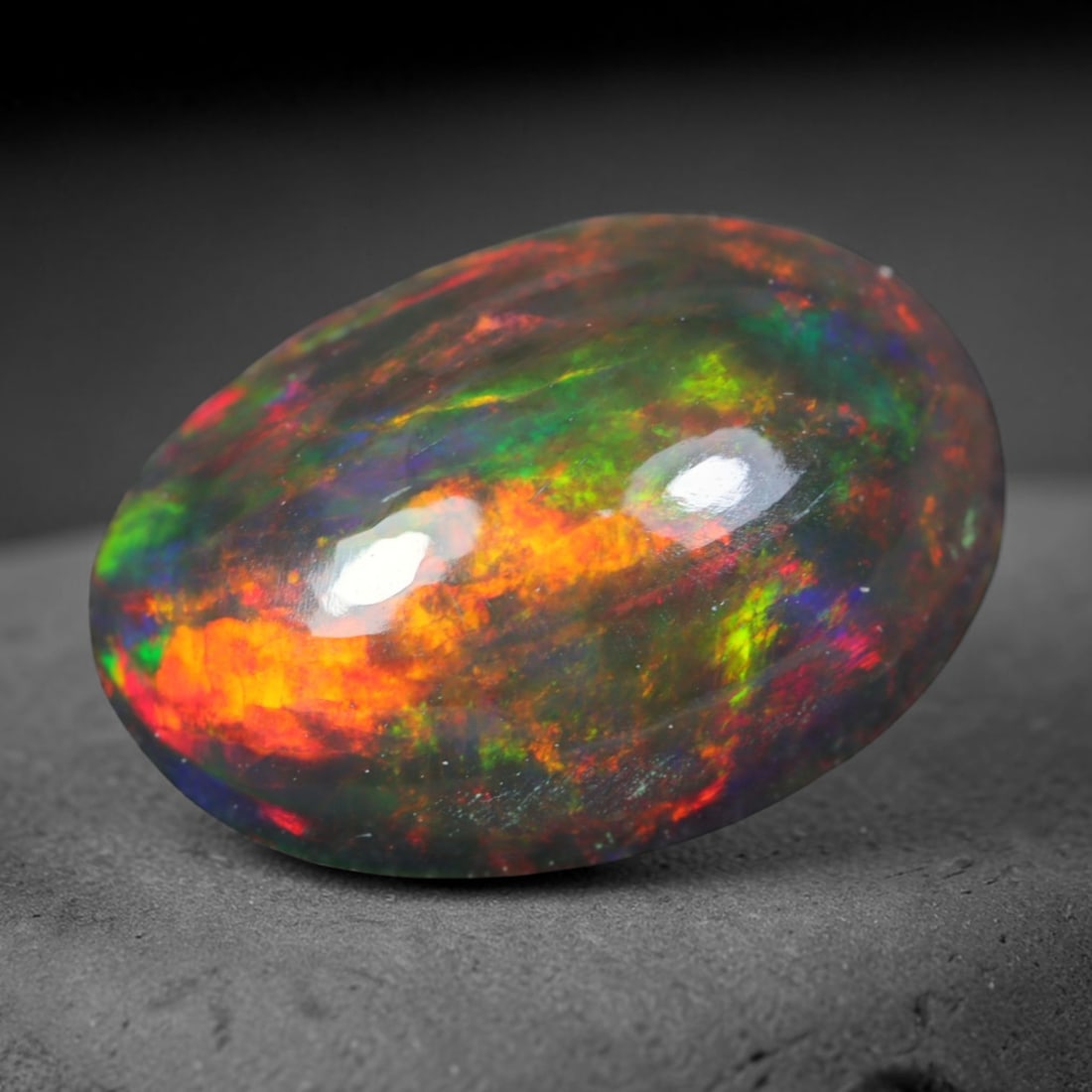 2.21ct Natural Ethiopian Welo Black Smoked Opal Cabochon Loose Gemstone, 69AK: This fully polished Ethiopian Welo opal features a dark smoked base with vivid, sweeping play-of-color shifting across its glossy dome surface, measured at 11.7x8.4x4.7mm. The black smoke treatment de