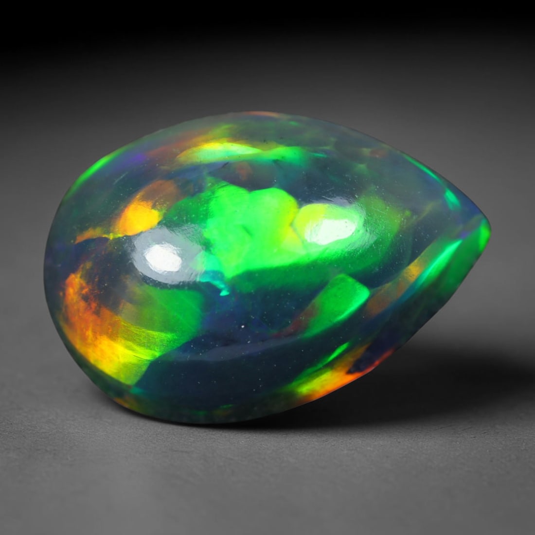 3.23ct Natural Ethiopian Welo Black Smoked Opal Cabochon Loose Gemstone, 62AK: This fully polished Ethiopian Welo opal features a dark smoked base with vivid, sweeping play-of-color shifting across its glossy dome surface, measured at 13x9x5.7mm. The black smoke treatment deepen