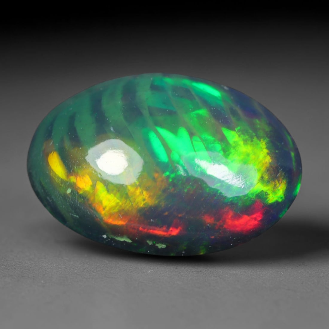 2.39ct Natural Ethiopian Welo Black Smoked Opal Cabochon Loose Gemstone, 77AK: This fully polished Ethiopian Welo opal features a dark smoked base with vivid, sweeping play-of-color shifting across its glossy dome surface, measured at 12x8.2x5.2mm. The black smoke treatment deep