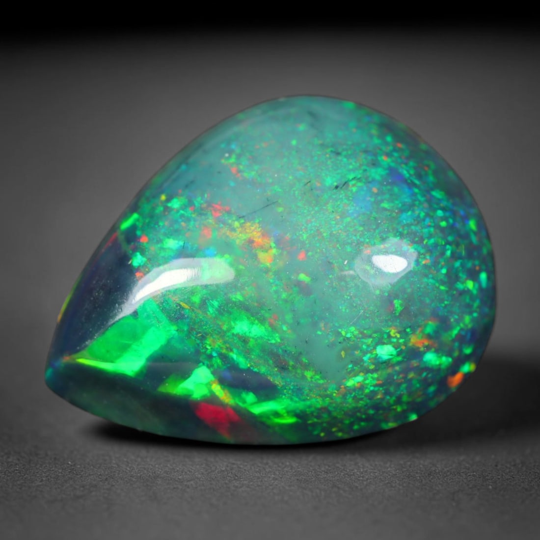 3.12ct Natural Ethiopian Welo Black Smoked Opal Cabochon Loose Gemstone, 90AK: This fully polished Ethiopian Welo opal features a dark smoked base with vivid, sweeping play-of-color shifting across its glossy dome surface, measured at 12.3x9.6x5.7mm. The black smoke treatment de