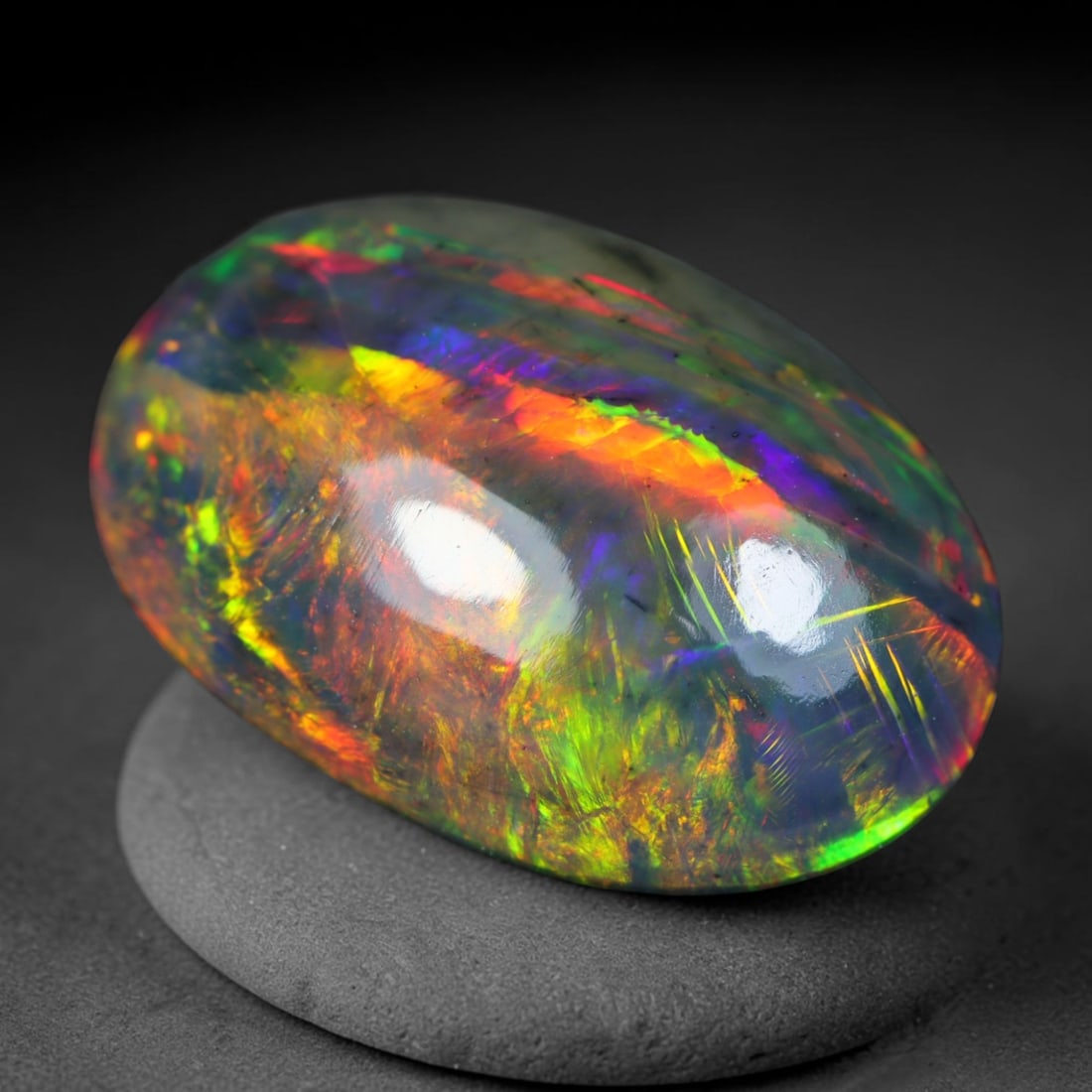 3.34ct Natural Ethiopian Welo Black Smoked Opal Cabochon Loose Gemstone, 71AK: This fully polished Ethiopian Welo opal features a dark smoked base with vivid, sweeping play-of-color shifting across its glossy dome surface, measured at 14.2x9.8x5mm. The black smoke treatment deep