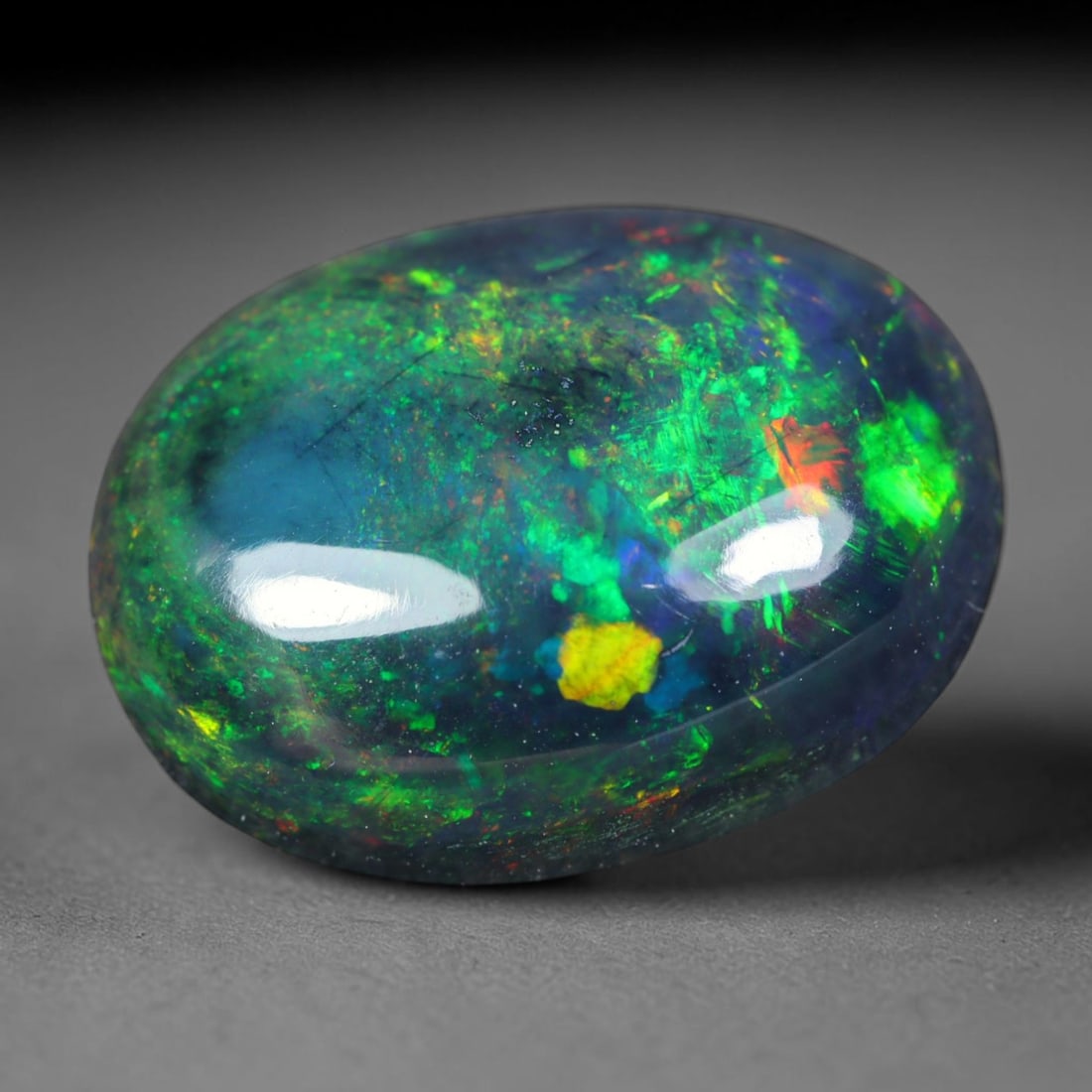 2.72ct Natural Ethiopian Welo Black Smoked Opal Cabochon Loose Gemstone, 70AK: This fully polished Ethiopian Welo opal features a dark smoked base with vivid, sweeping play-of-color shifting across its glossy dome surface, measured at 12.3x9.2x4.8mm. The black smoke treatment de