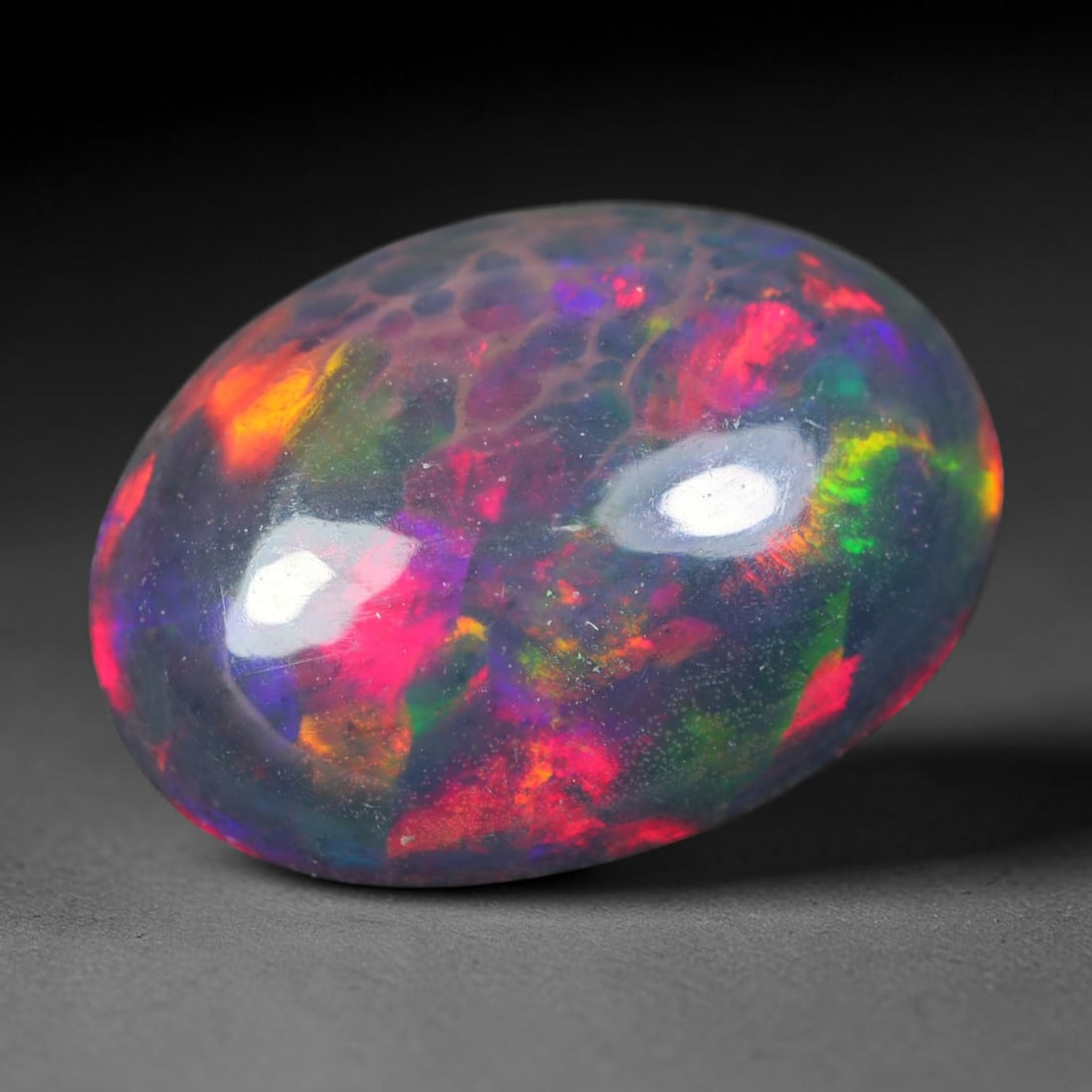 2.25ct Natural Ethiopian Welo Black Smoked Opal Cabochon Loose Gemstone, 61AK: This fully polished Ethiopian Welo opal features a dark smoked base with vivid, sweeping play-of-color shifting across its glossy dome surface, measured at 12.3x8.9x4.3mm. The black smoke treatment de