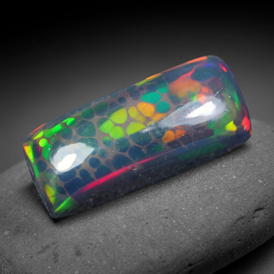 2.55ct Natural Ethiopian Welo Black Smoked Opal Cabochon Loose Gemstone, 60AK: This fully polished Ethiopian Welo opal features a dark smoked base with vivid, sweeping play-of-color shifting across its glossy dome surface, measured at 14.7x6.3x4.8mm. The black smoke treatment de