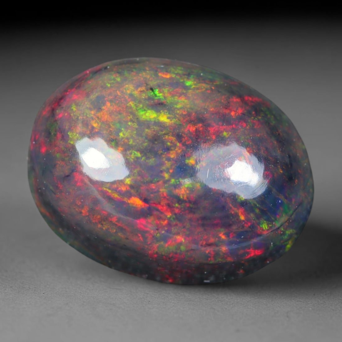 2.86ct Natural Ethiopian Welo Black Smoked Opal Cabochon Loose Gemstone, 74AK: This fully polished Ethiopian Welo opal features a dark smoked base with vivid, sweeping play-of-color shifting across its glossy dome surface, measured at 11.3x8.5x5.6mm. The black smoke treatment de