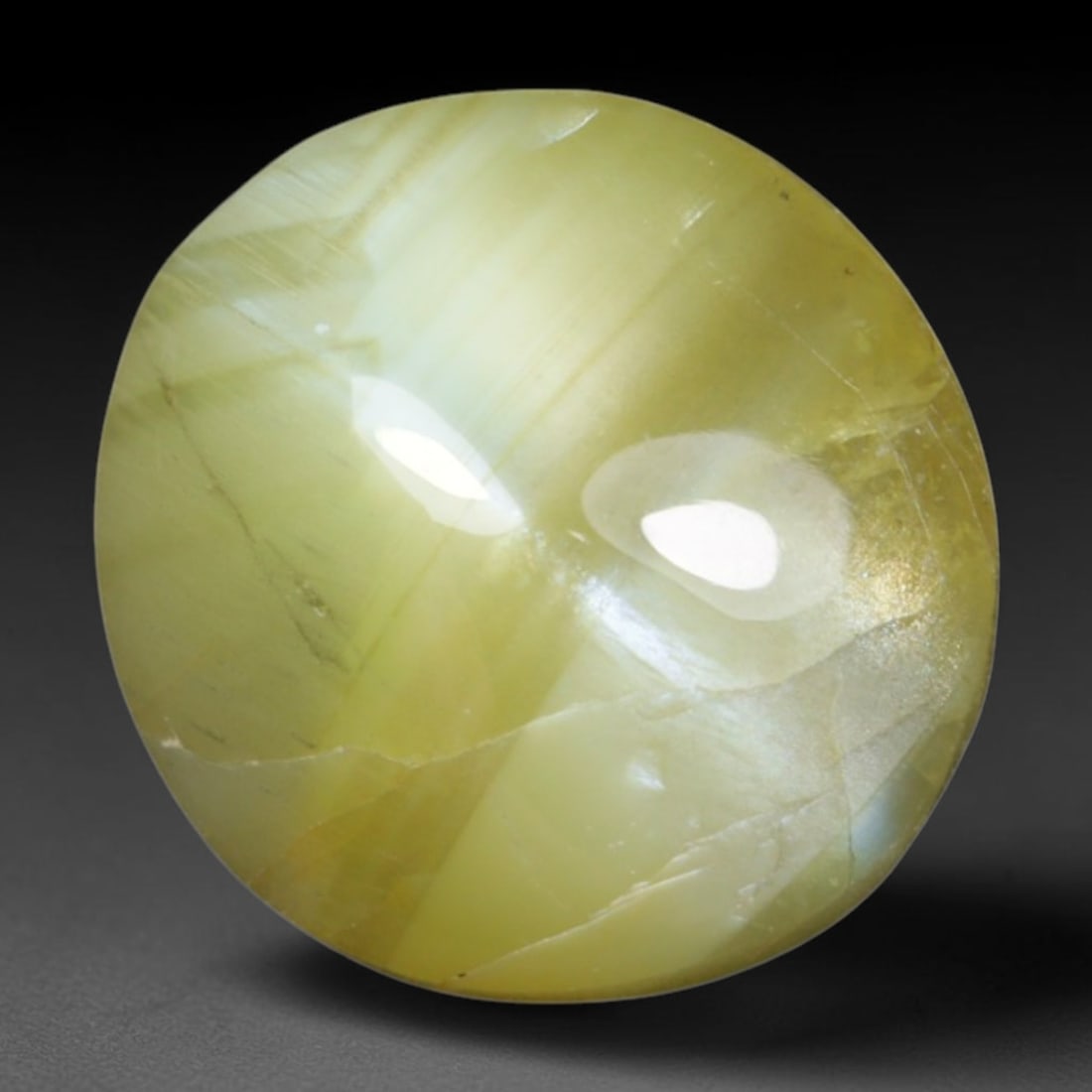 1.68 Carats Natural Ceylon Chrysoberyl Cat's Eye Loose Gemstone, 5AL: This polished Ceylon chrysoberyl cabochon displays a sharp, distinct silvery chatoyant band running across its smooth surface, formed by dense aligned microscopic rutile inclusions inherent to genuine