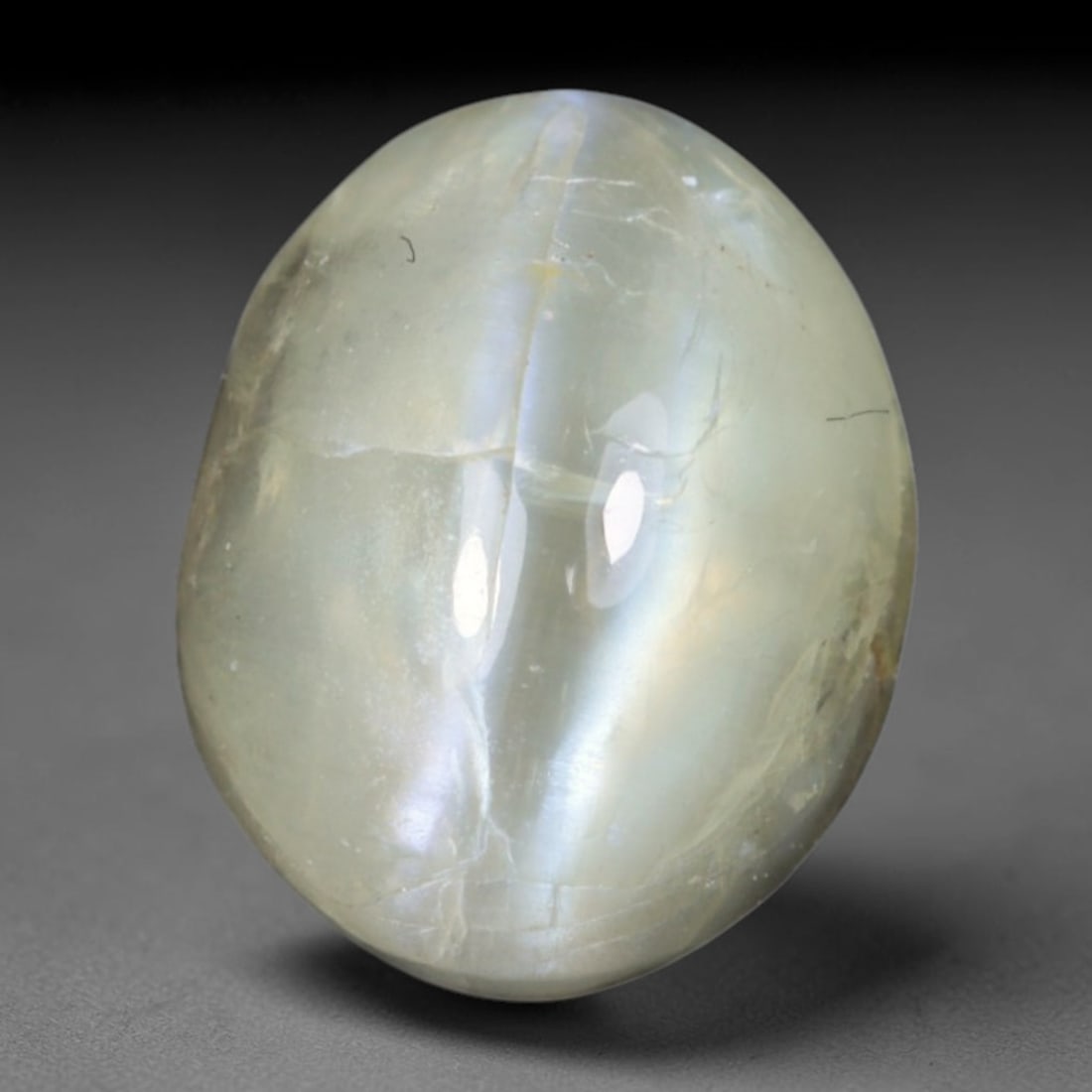 1.76 Carats Natural Ceylon Chrysoberyl Cat's Eye Loose Gemstone, 7AL: This polished Ceylon chrysoberyl cabochon displays a sharp, distinct silvery chatoyant band running across its smooth surface, formed by dense aligned microscopic rutile inclusions inherent to genuine