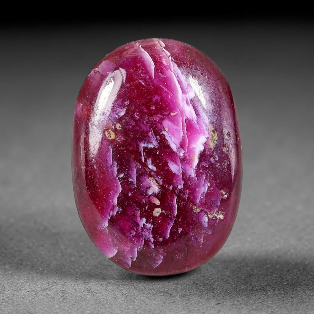 25.66 Carats Natural Mozambique Vivid Pink Red Ruby Loose Gemstone, 94FG: This polished Mozambique ruby cabochon measures 24x17.4x5.1mm, featuring striking natural swirling white mineral banding layered across a rich saturated pink red base that creates a unique organic art