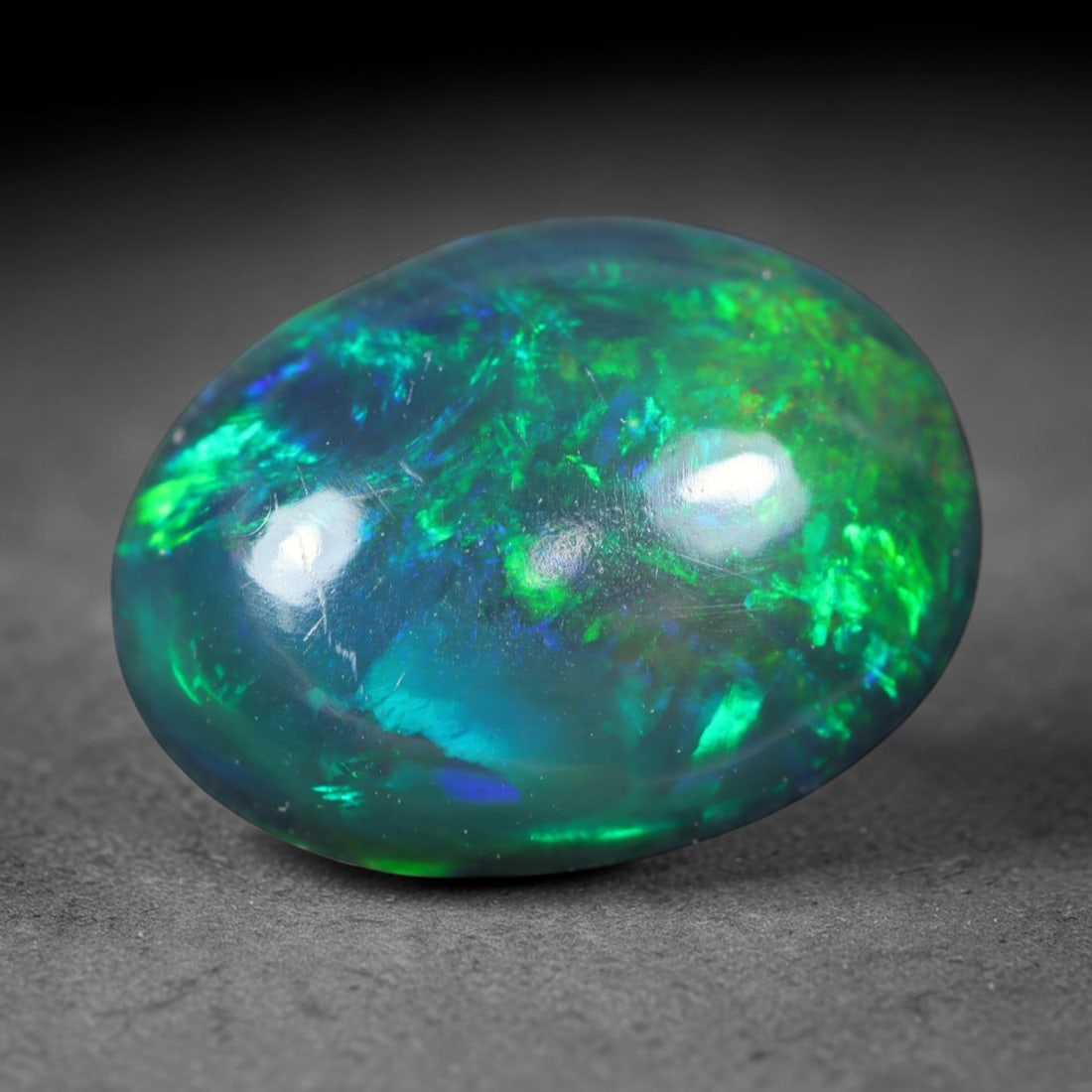 2.62ct Natural Ethiopian Welo Black Smoked Opal Cabochon Loose Gemstone, 43FL: This fully polished Ethiopian Welo opal features a dark smoked base with vivid, sweeping play-of-color shifting across its glossy dome surface, measured at 11.5x9x4.9mm. The black smoke treatment deep