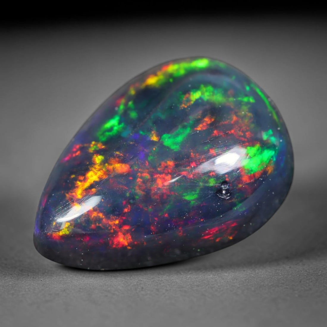 1.95ct Natural Ethiopian Welo Black Smoked Opal Cabochon Loose Gemstone, 11FL: This fully polished Ethiopian Welo opal features a dark smoked base with vivid, sweeping play-of-color shifting across its glossy dome surface, measured at 11.7x8.7x4.6mm. The black smoke treatment de