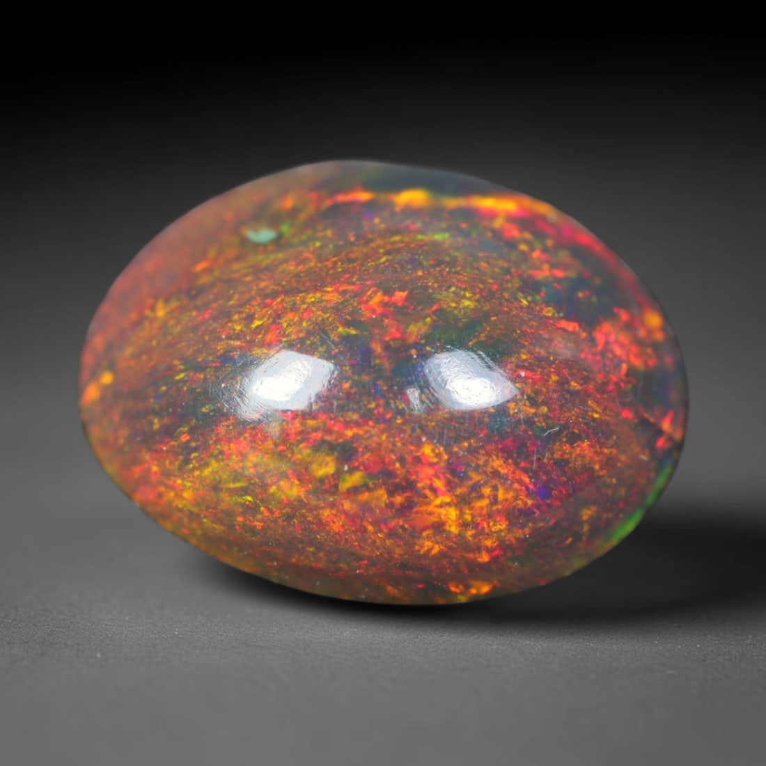 1.61ct Natural Ethiopian Welo Black Smoked Opal Cabochon Loose Gemstone, 3FL: This fully polished Ethiopian Welo opal features a dark smoked base with vivid, sweeping play-of-color shifting across its glossy dome surface, measured at 10.5x8.5x4.5mm. The black smoke treatment de
