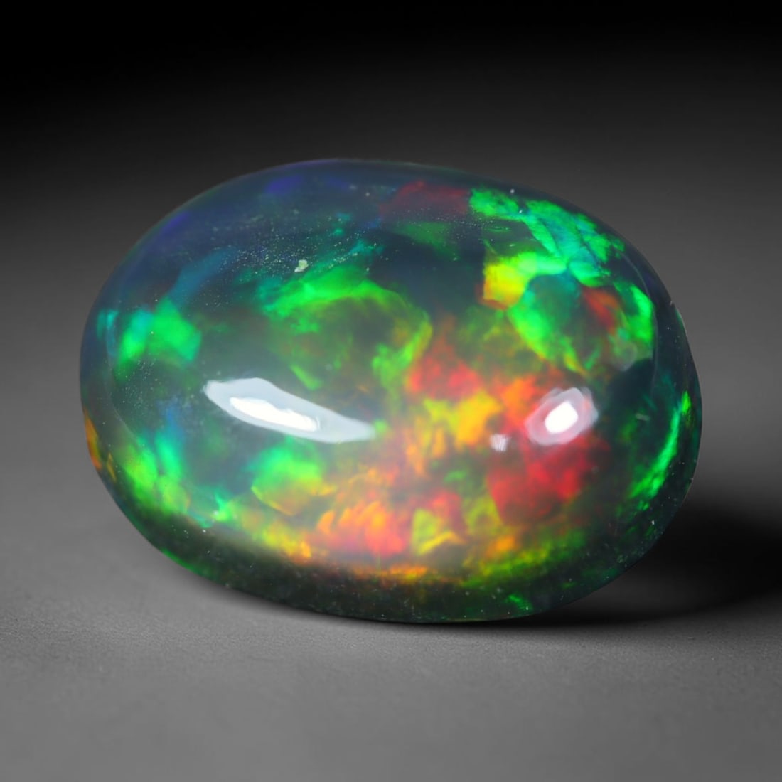 2.92ct Natural Ethiopian Welo Black Smoked Opal Cabochon Loose Gemstone, 42FL: This fully polished Ethiopian Welo opal features a dark smoked base with vivid, sweeping play-of-color shifting across its glossy dome surface, measured at 11.6x9x4.8mm. The black smoke treatment deep