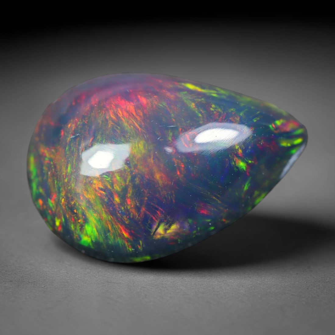 2.53ct Natural Ethiopian Welo Black Smoked Opal Cabochon Loose Gemstone, 89AK: This fully polished Ethiopian Welo opal features a dark smoked base with vivid, sweeping play-of-color shifting across its glossy dome surface, measured at 12.7x9.1x5.2mm. The black smoke treatment de