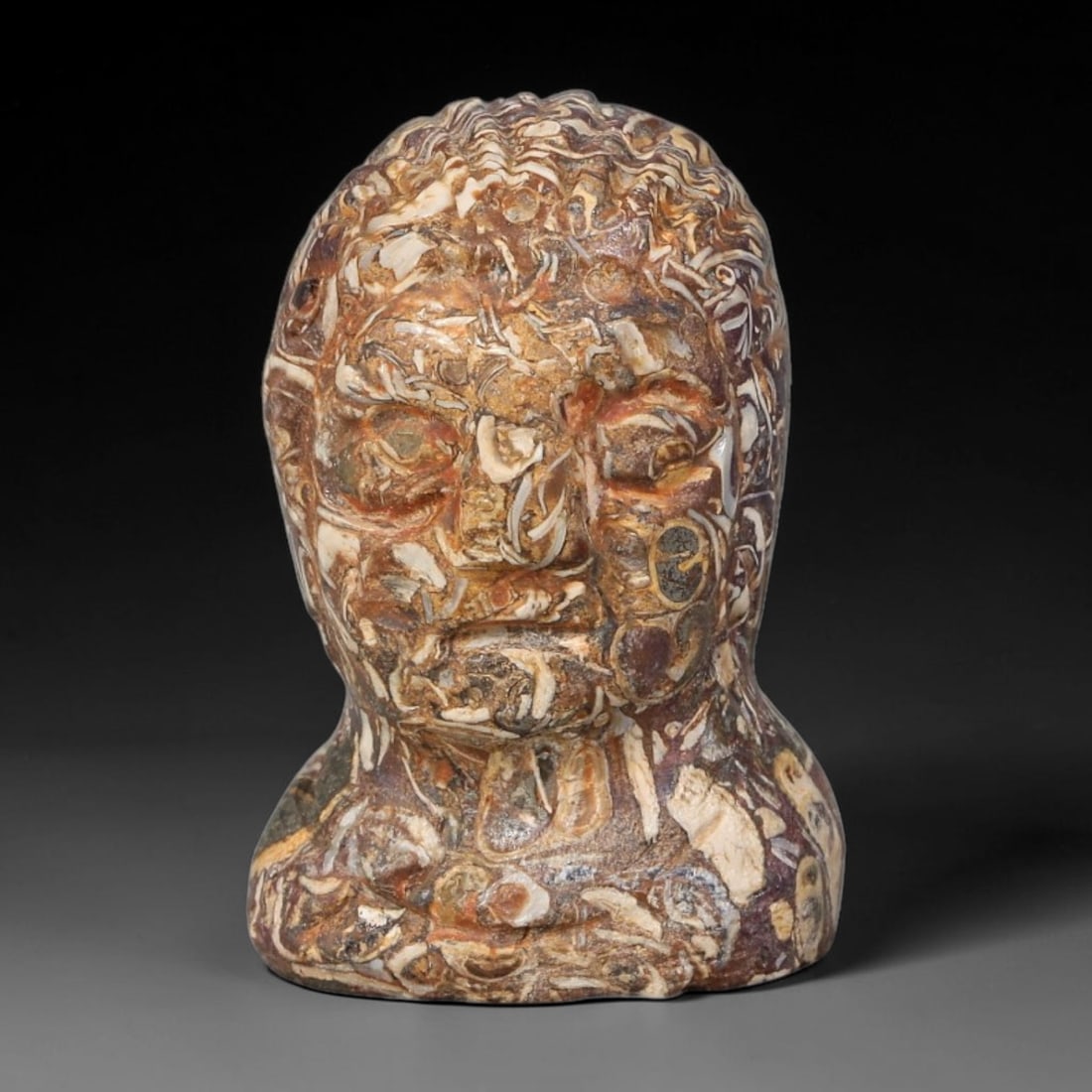 Ancient Western Asiatic Human Bust Ritual Talisman (1000-600 BCE), 14AB: Hand-carved brecciated jasper human bust ornament showcasing natural swirling cream, rust and dark brown mineral veining throughout the stone matrix. Detailed incised carving renders stylized hair, de