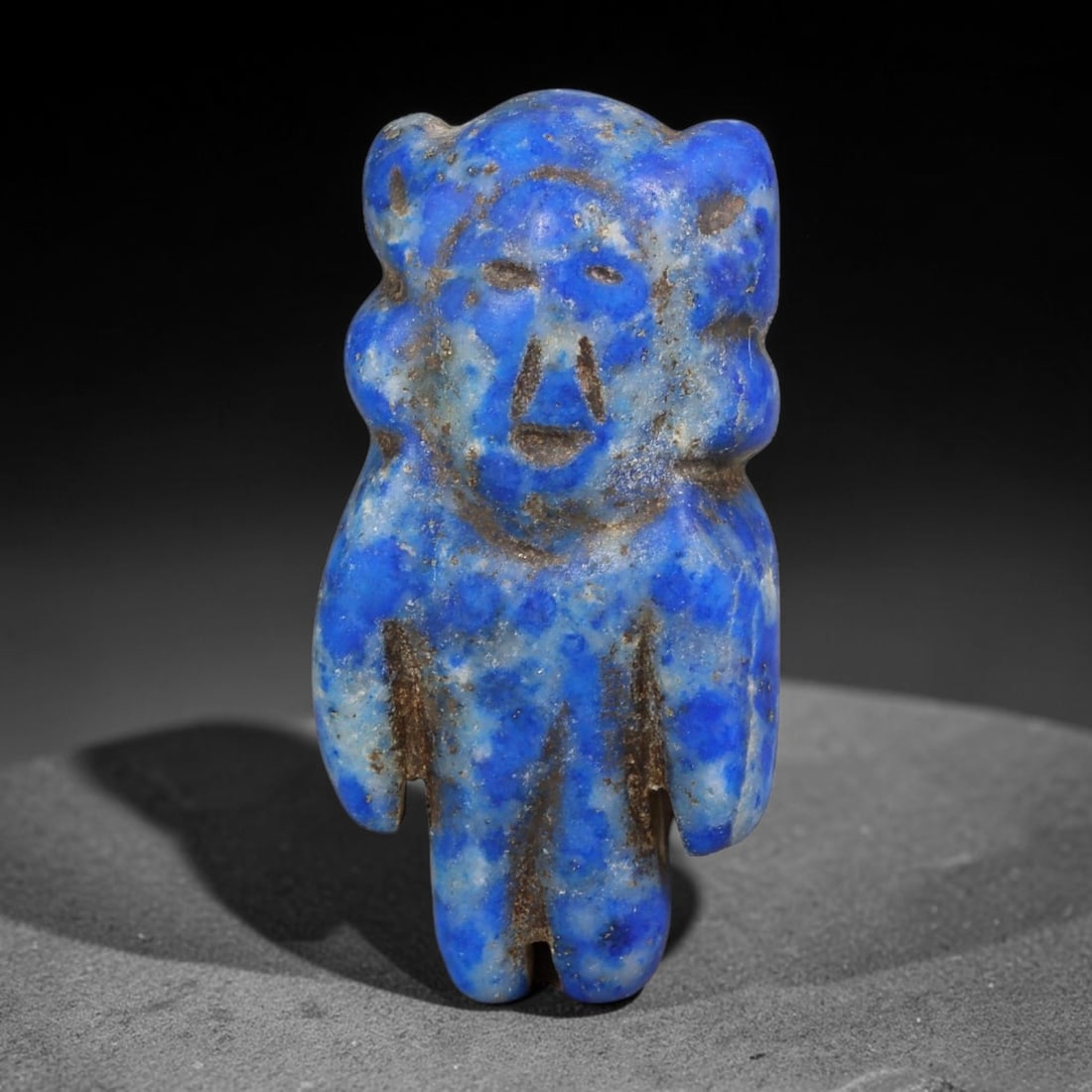 Ancient Near Eastern Natural Lapis Lazuli Anthropomorphic Human Figurine Amulet (1200-600 BCE), 90AE: Hand-carved natural lapis lazuli miniature anthropomorphic talisman featuring a stylized human form with simplified facial incisions, rounded ear protrusions, and unified block limbs. Deep royal blue 