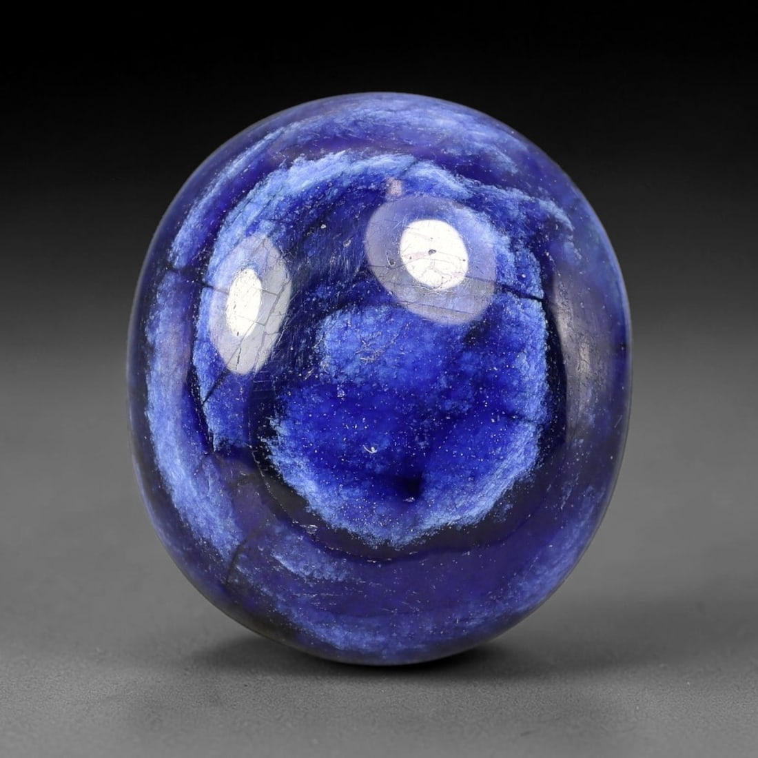 24.70 Carats Natural Madagascar Deep Cobalt Blue Sapphire Loose Gemstone, 23FE: This Madagascar sapphire cabochon has dimensions measuring 19.2x17x6.6mm, featuring rich cobalt blue color blended with soft natural pale veining that creates unique layered visual texture across the 