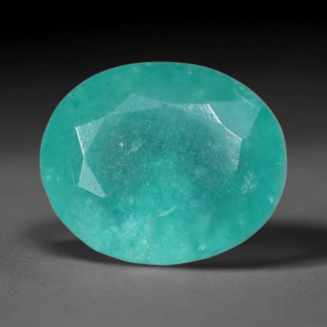 6.19 Carats Natural Brazilian Soft Mint Green Beryl Loose Gemstone, 2FE: This natural Brazilian green beryl measures 12.2x10.1x7.3mm, presenting a soft uniform mint green tone throughout its translucent crystal matrix, dotted with fine scattered dark mineral specks and sub