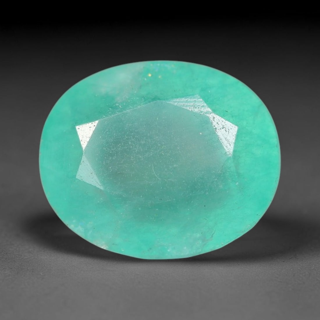 6.32 Carats Natural Brazilian Soft Mint Green Beryl Loose Gemstone, 100FE: This natural Brazilian green beryl measures 12.5x10.4x7mm, presenting a soft uniform mint green tone throughout its translucent crystal matrix, dotted with fine scattered dark mineral specks and subtl