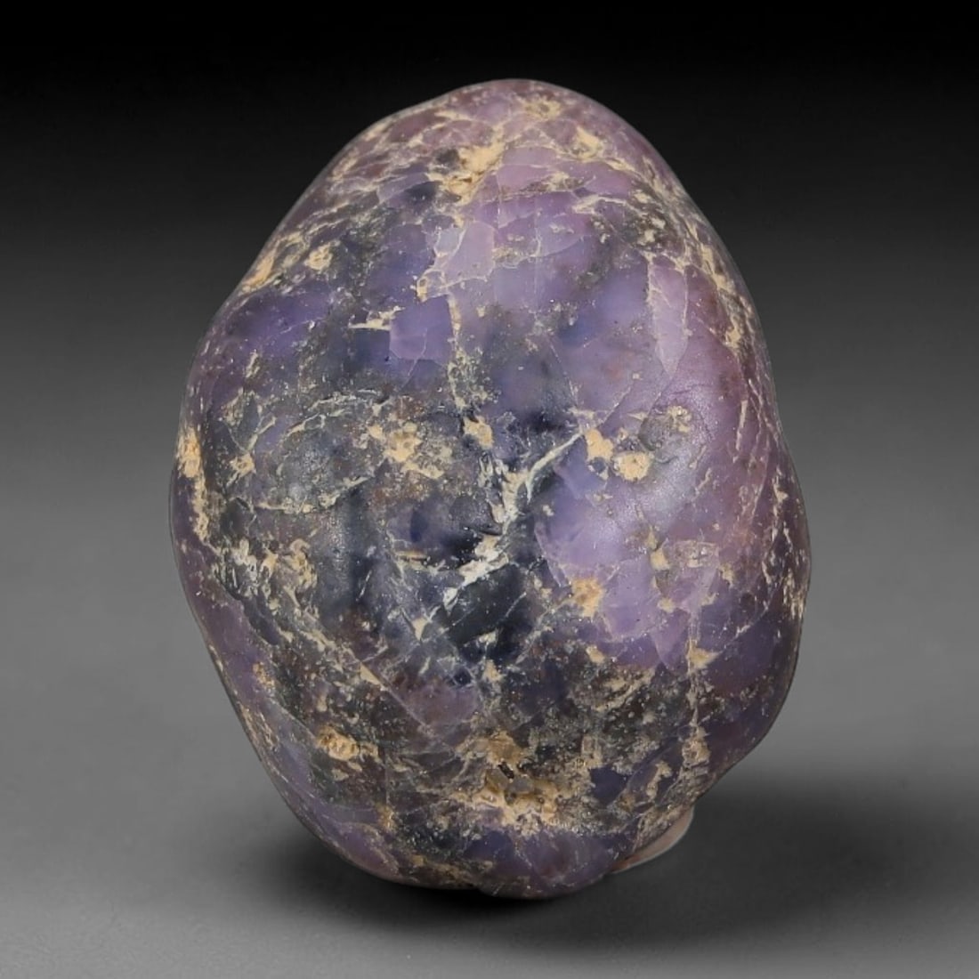 25.95ct Natural Unheated Sri Lankan Purplish Blue Sapphire Rough, 76FC: This natural corundum rough is an unheated purplish blue sapphire sourced from Sri Lankan alluvial gem deposits, featuring an irregular natural native form with residual pale yellow-brown mineral matr