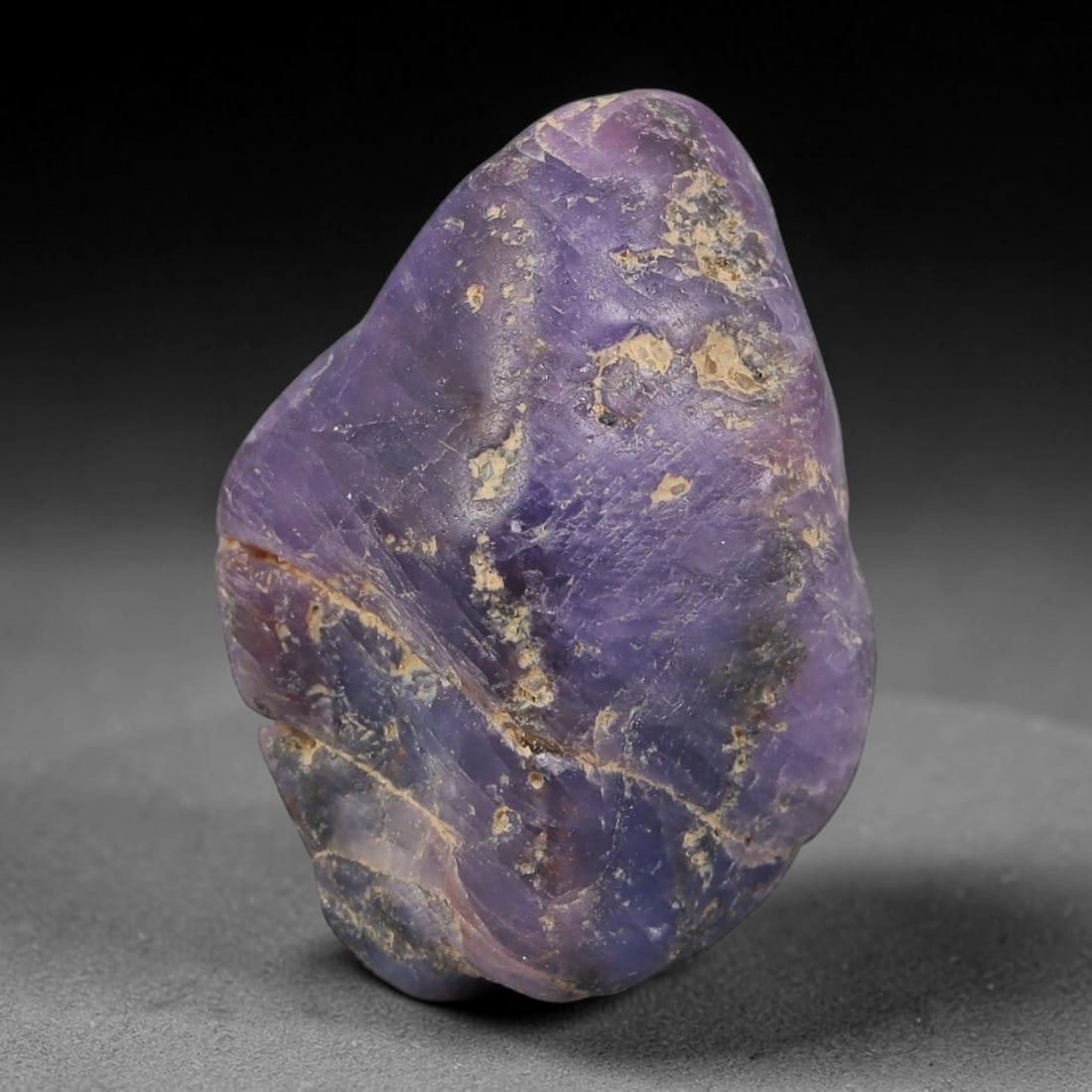 50.46ct Natural Unheated Sri Lankan Purplish Blue Sapphire Rough, 59FC: This natural corundum rough is an unheated purplish blue sapphire sourced from Sri Lankan alluvial gem deposits, featuring an irregular natural native form with residual pale yellow-brown mineral matr