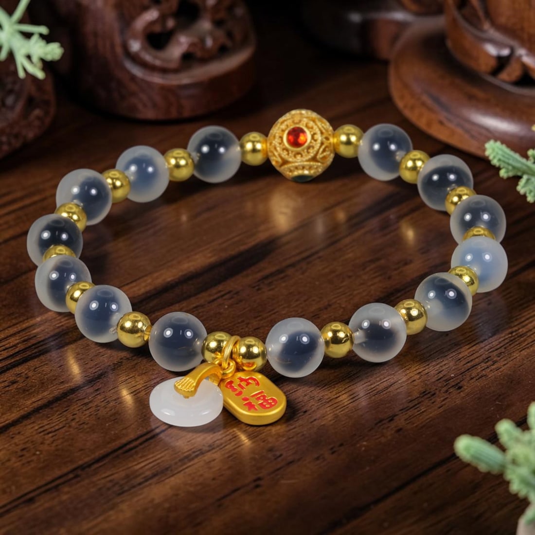 A Chinese Glass Beaded Bracelet - Frosted Grey Glass Gilded Charm Strand, 8AP: Hand-strung bracelet constructed with smooth 8mm frosted translucent grey glass round beads, separated by polished small gilded metal spacer beads. A central ornate filigree gilded focal bead set with