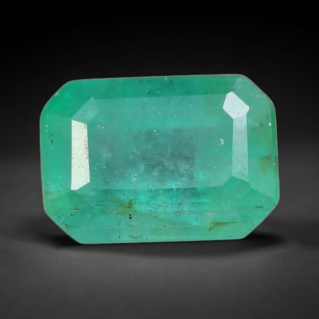 1.01 Carats Natural Zambian Green Emerald Loose Gemstone, 12FP: This green Zambian emerald holds smooth even saturation with subtle faint natural internal markings lending authentic organic character, measured at 6.7x4.7x4mm, its calm cool green tone delivers unde