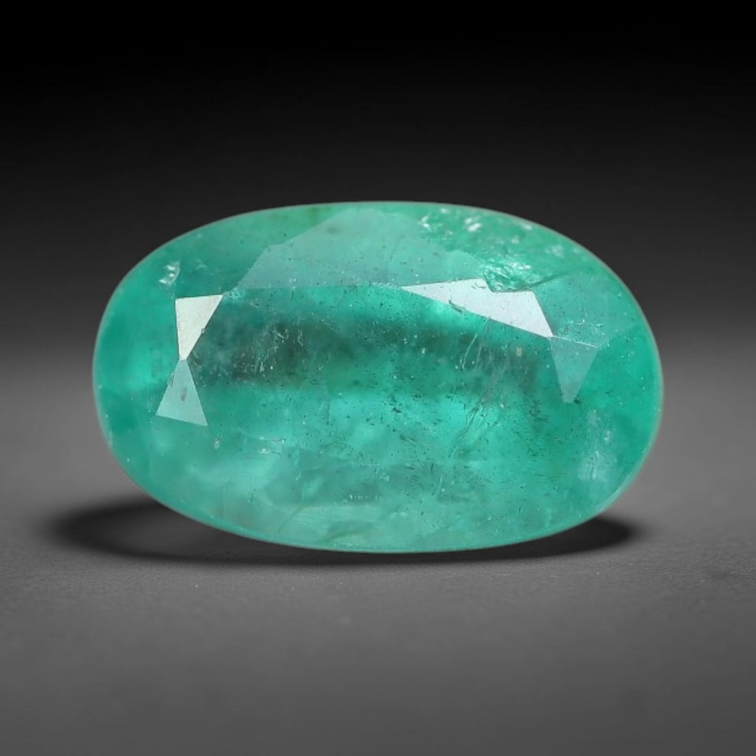 0.97 Carats Natural Zambian Green Emerald Loose Gemstone, 3FP: This green Zambian emerald holds smooth even saturation with subtle faint natural internal markings lending authentic organic character, measured at 8x5x3.7mm, its calm cool green tone delivers unders