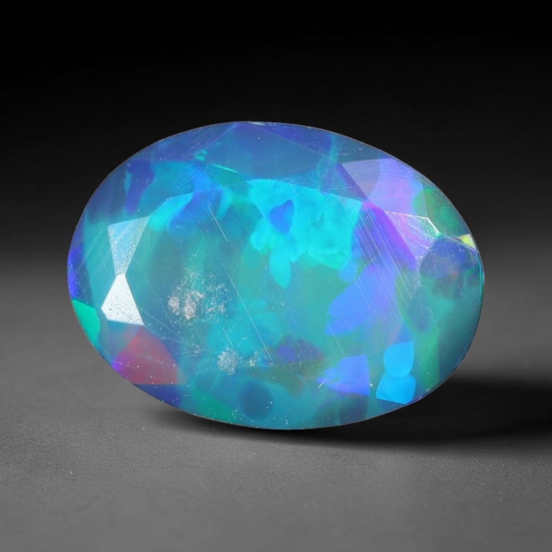 1.15ct Natural Ethiopian Welo Black Smoked Faceted Opal, 15EB: This fully faceted finished opal specimen displays vivid shifting play of color across polished geometric facets within its 9.6x1.7x4mm calibrated dimensions, the dark base body amplifies light moveme