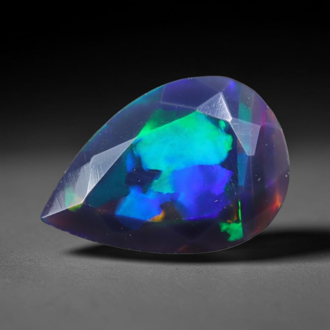 1.29ct Natural Ethiopian Welo Black Smoked Faceted Opal, 18EB: This fully faceted finished opal specimen displays vivid shifting play of color across polished geometric facets within its 10.8x7.4x4.6mm calibrated dimensions, the dark base body amplifies light mov