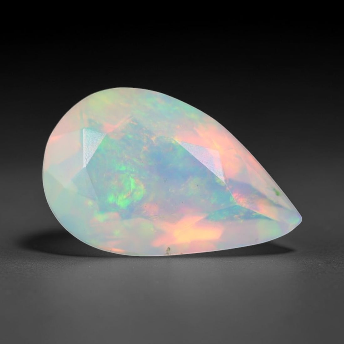 0.89ct Natural Ethiopian Welo Faceted Opal, 8EB: This expertly faceted finished opal holds soft shifting internal light phenomena visible across polished reflective planes within its 9.4x5.9x4.2mm calibrated measurements, precise faceting structure 