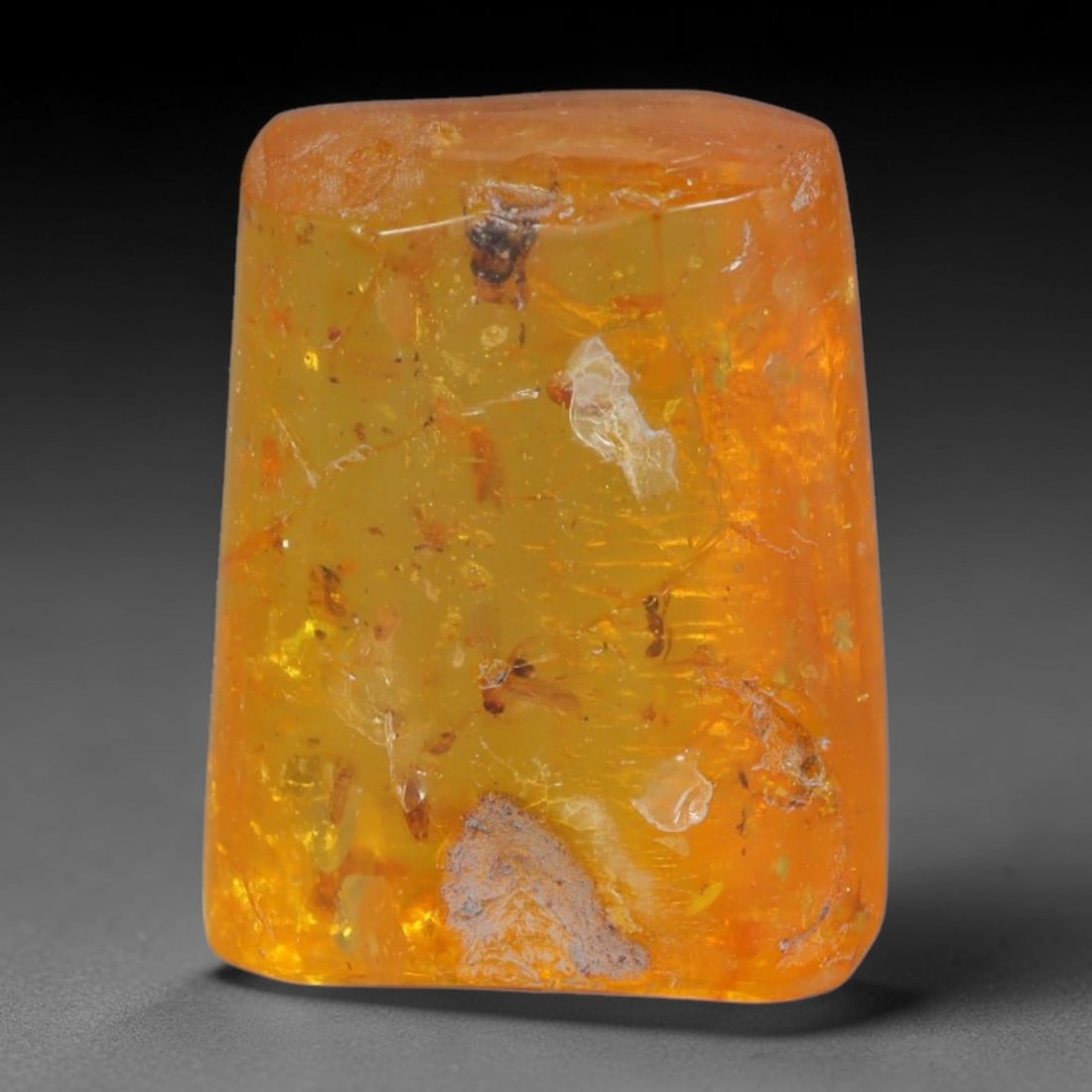 19.62ct Natural Baltic Polished Loose Freeform Amber Gemstone, 29AT: This smoothly polished freeform amber piece carries warm translucent organic clarity with fine natural fossil flecks and tiny mineral inclusions suspended throughout its 23x18mm flowing unstructured s