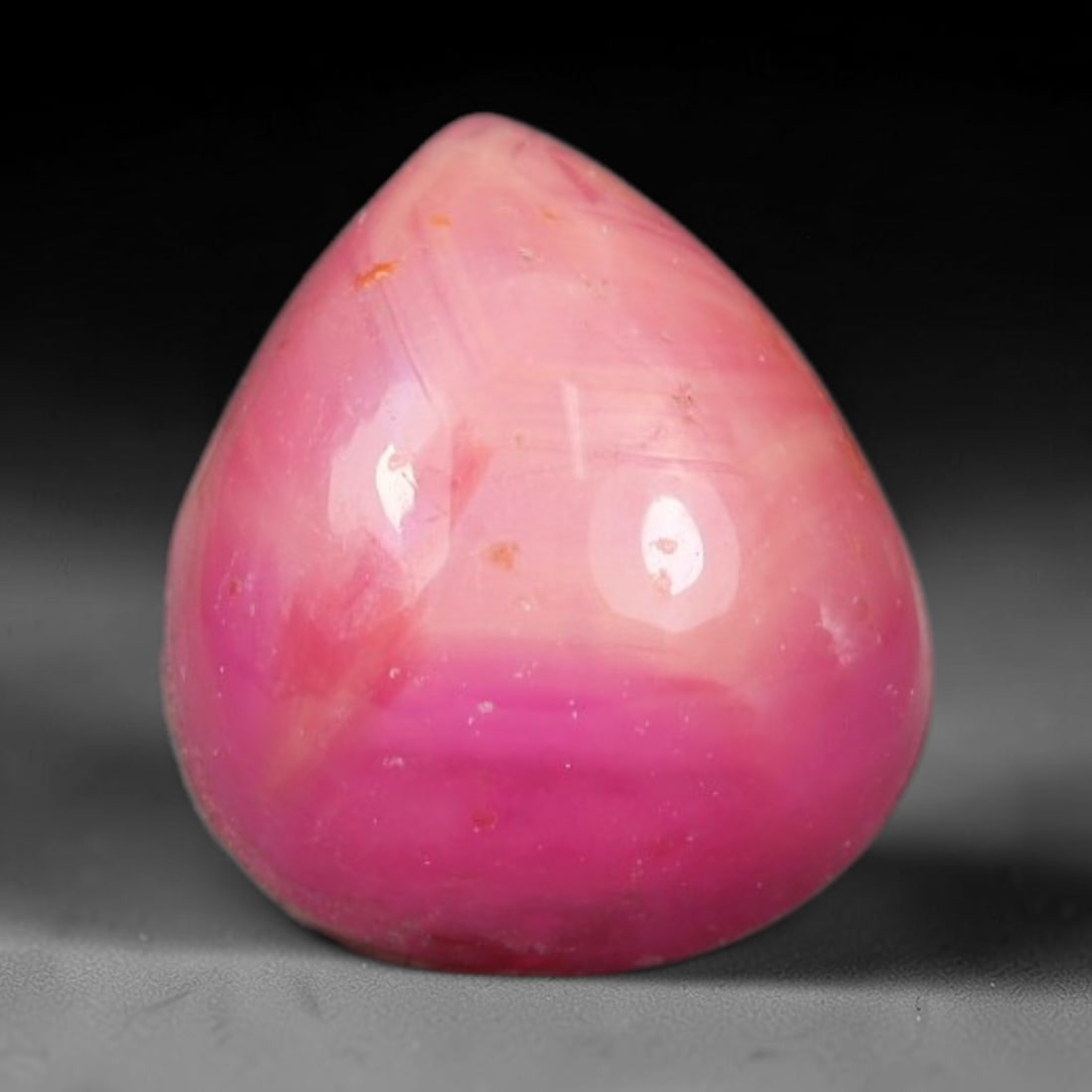 2.33ct Natural Mozambican Soft Bubblegum Pink Ruby Cabochon Loose Gemstone, 97AR: This smoothly polished domed ruby cabochon displays a gentle soft bubblegum pink body tone with faint natural linear mineral veining and tiny scattered rust-hued mineral flecks embedded within its tra