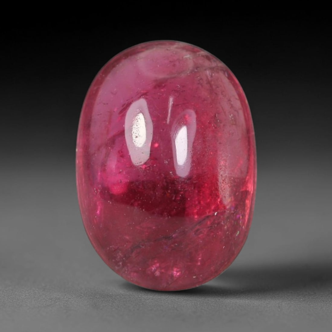 2.04ct Natural Brazilian Rubellite Tourmaline Cabochon Loose Gemstone, 45BC: This smoothly polished cabochon rubellite tourmaline features layered saturated pink-red body saturation with dense natural crystalline mineral flecks and fine internal fracture markings concentrated 