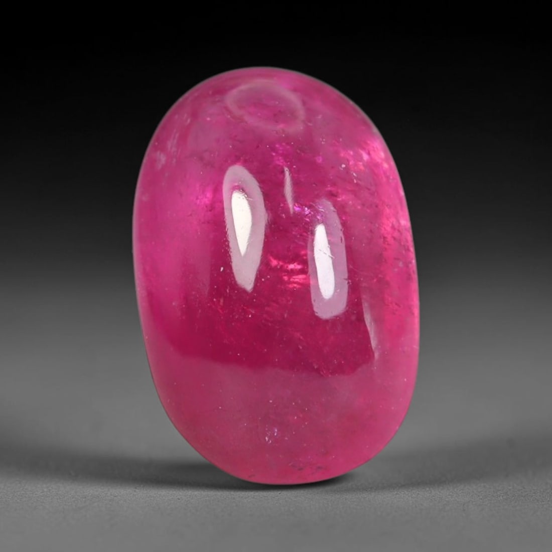 2.45ct Natural Brazilian Rubellite Tourmaline Cabochon Loose Gemstone, 16BC: This smoothly polished cabochon rubellite tourmaline features layered saturated pink-red body saturation with dense natural crystalline mineral flecks and fine internal fracture markings concentrated 