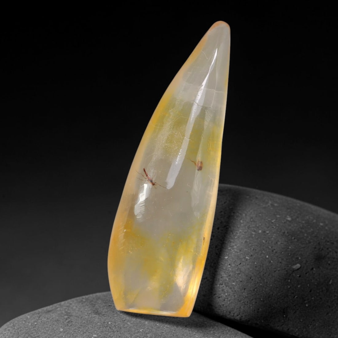 20.60ct Natural Baltic Polished Loose Freeform Amber Gemstone, 32AT: This smoothly polished freeform amber piece carries warm translucent organic clarity with fine natural fossil flecks and tiny mineral inclusions suspended throughout its 45x15mm flowing unstructured s