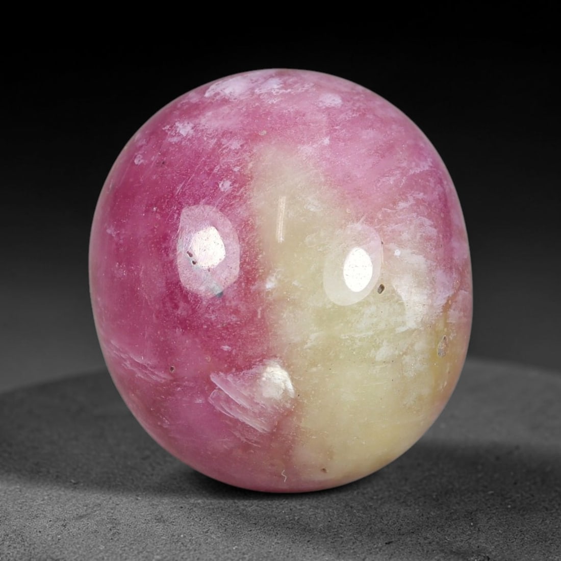 23.20 Carats Natural Mozambique Bicolor Ruby Loose Gemstone, 51FG: This natural Mozambique bicolor ruby cabochon holds dimension measurements of 15.2x13.7x9.4mm, displaying soft swirled intermix of rich pink and pale creamy mineral tones that blend seamlessly across 