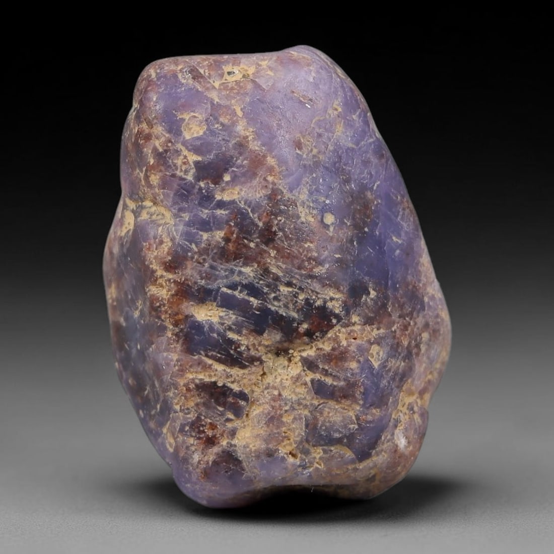 49.47ct Natural Unheated Sri Lankan Purplish Blue Sapphire Rough, 68FC: This natural corundum rough is an unheated purplish blue sapphire sourced from Sri Lankan alluvial gem deposits, featuring an irregular natural native form with residual pale yellow-brown mineral matr