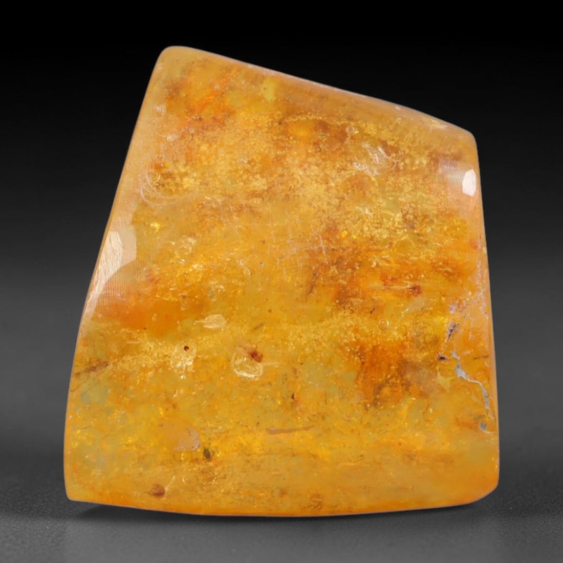 15ct Natural Baltic Polished Loose Freeform Amber Gemstone, 80AT: This smoothly polished freeform amber piece carries warm translucent organic clarity with fine natural fossil flecks and tiny mineral inclusions suspended throughout its 24x22mm flowing unstructured s