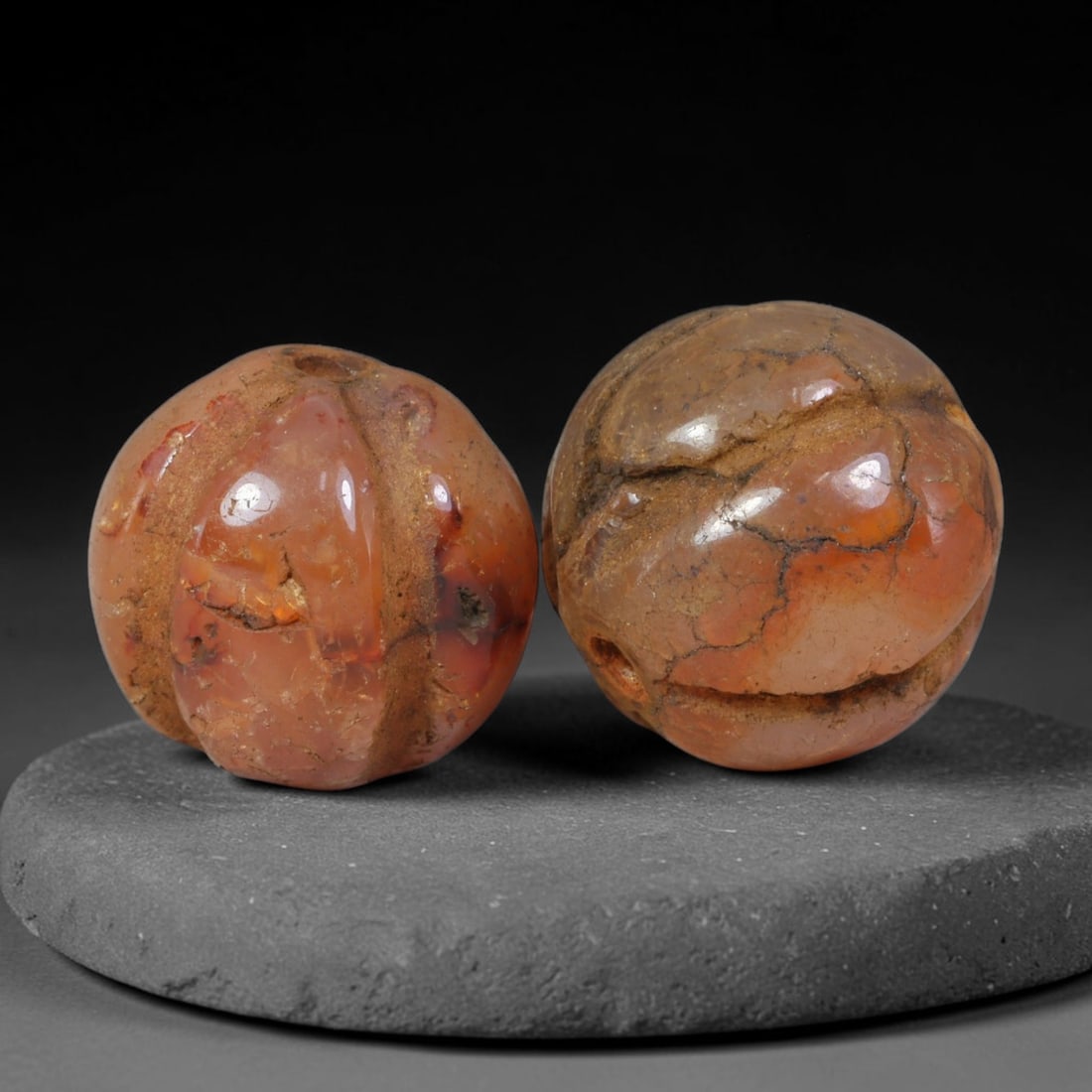 Ancient Medieval Khmer Angkor Culture Carved Carnelian Melon Bead Pair (802-1431 CE), 43AE: This matched pair of antique hand-carved melon form carnelian beads originates from Khmer Angkor Culture, the medieval Southeast Asian civilization renowned for crafting ritual chalcedony adornments f