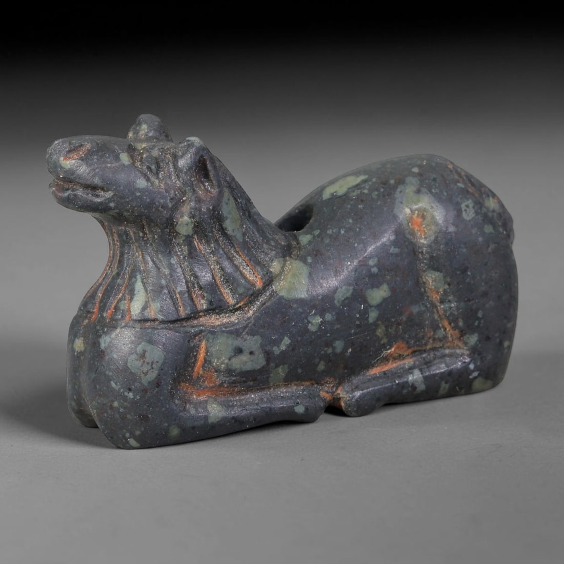 Ancient Sasanian Persian Speckled Stone Recumbent Horse Amulet (224-651 CE), 24AB: This dark mottled speckled stone horse figurine originates from Sasanian Persian Culture, animal talismans symbolizing strength and protection worn as portable burial and personal adornment. Fine inci