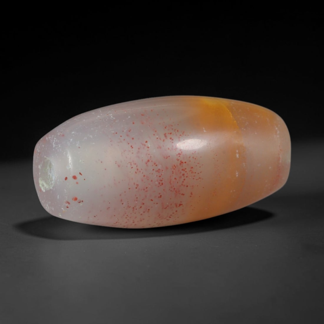 Ancient Kushan Empire Banded Agate Barrel Bead (30 BCE - 375 CE), 56AD: This antique banded agate barrel bead originates from the Kushan Empire, a pivotal cross-cultural power linking Central Asia, India and the Near East with specialized agate bead ateliers producing amu