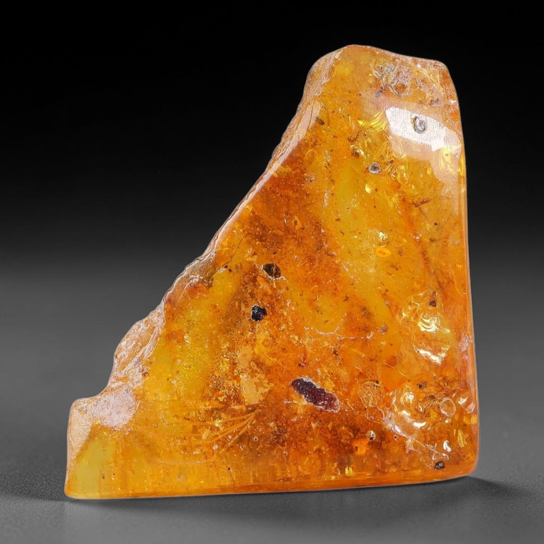 16ct Natural Baltic Polished Loose Freeform Amber Gemstone, 59EB: This smoothly polished freeform amber piece carries warm translucent organic clarity with fine natural fossil flecks and tiny mineral inclusions suspended throughout its 27x25mm flowing unstructured s