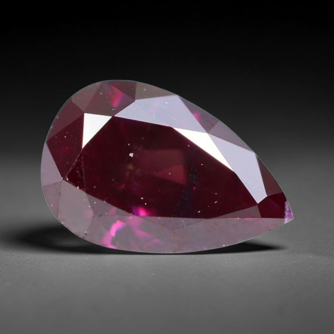 0.25ct Natural Fancy Deep Pink Diamond Loose Gemstone, 25BH: This polished natural fancy diamond features rich deep pink colouration, measured at calibrated dimensions of 35.3x3.5x2mm. Carefully proportioned pear faceting delivers dynamic light movement, highli