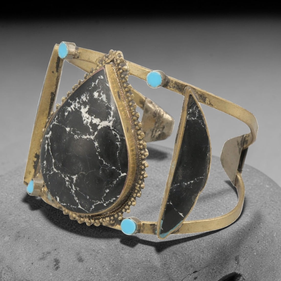 A Vintage Himalayan Stone Inlay Cuff Bracelet, 30AH: A handcrafted vintage cuff bracelet, measuring approximately 7 cm in width, featuring traditional Himalayan jewelry design. The piece has a brass-toned metal base, showcasing a large teardrop-shaped b