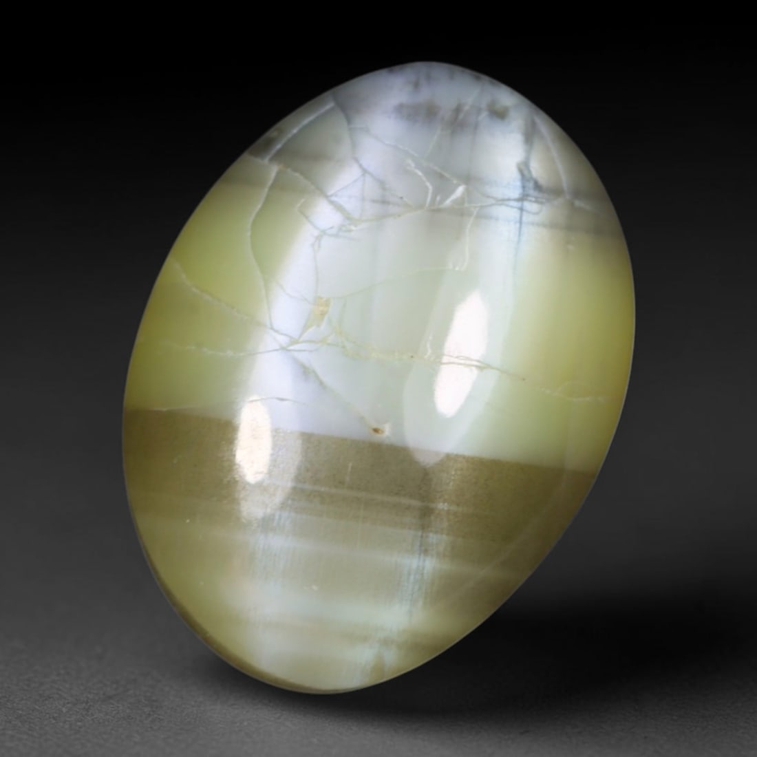 2.16 Carats Natural Ceylon Chrysoberyl Cat's Eye Loose Gemstone, 6AL: This polished Ceylon chrysoberyl cabochon displays a sharp, distinct silvery chatoyant band running across its smooth surface, formed by dense aligned microscopic rutile inclusions inherent to genuine