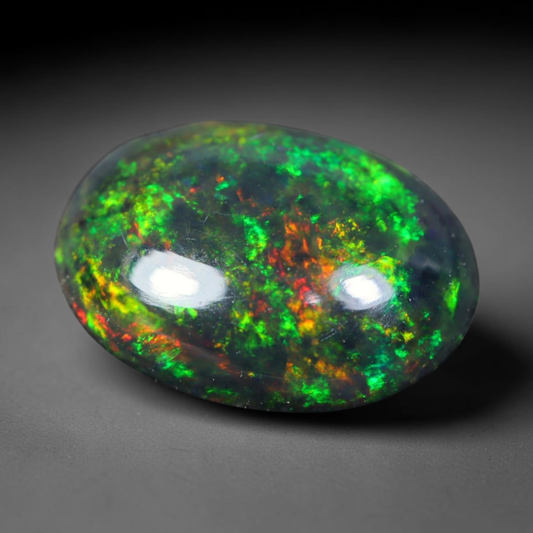 1.55ct Natural Ethiopian Welo Black Smoked Opal Cabochon Loose Gemstone, 41FL: This fully polished Ethiopian Welo opal features a dark smoked base with vivid, sweeping play-of-color shifting across its glossy dome surface, measured at 10.7x7.9x3.8mm. The black smoke treatment de