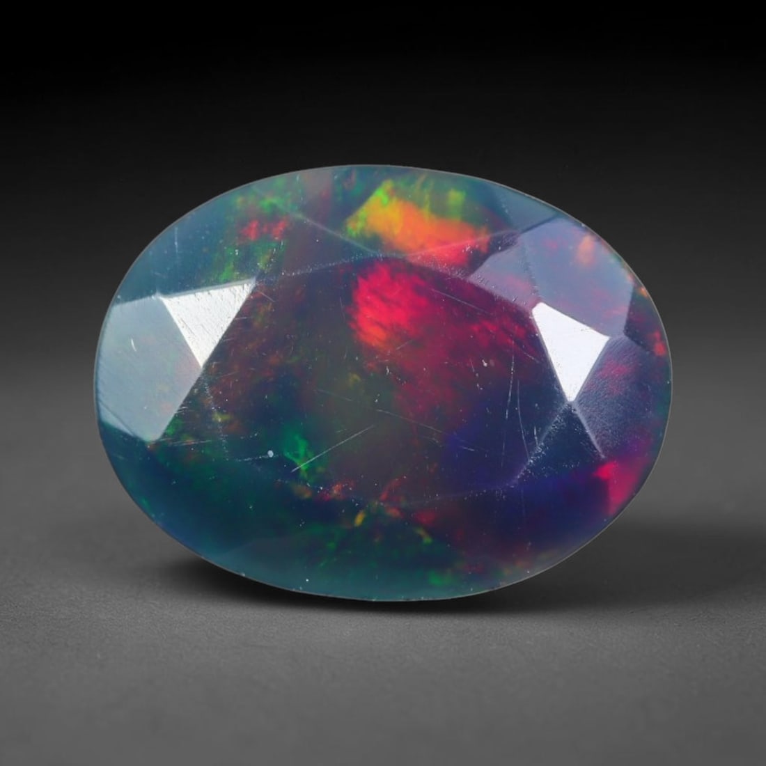 1.34ct Natural Ethiopian Welo Black Smoked Faceted Opal, 19EB: This fully faceted finished opal specimen displays vivid shifting play of color across polished geometric facets within its 9.7x6.4x4.9mm calibrated dimensions, the dark base body amplifies light move