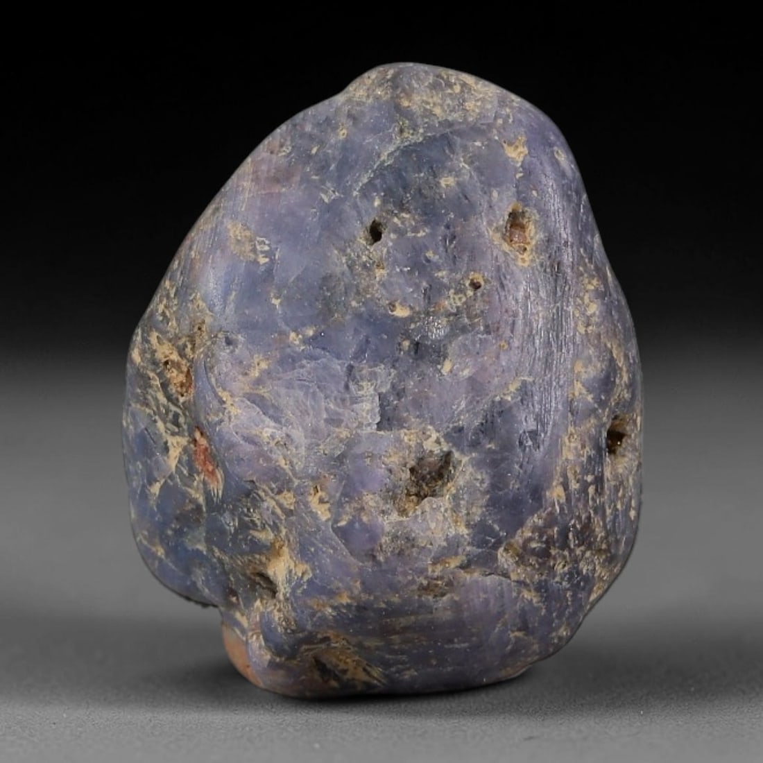 28.83ct Natural Unheated Sri Lankan Purplish Blue Sapphire Rough, 84FC: This natural corundum rough is an unheated purplish blue sapphire sourced from Sri Lankan alluvial gem deposits, featuring an irregular natural native form with residual pale yellow-brown mineral matr