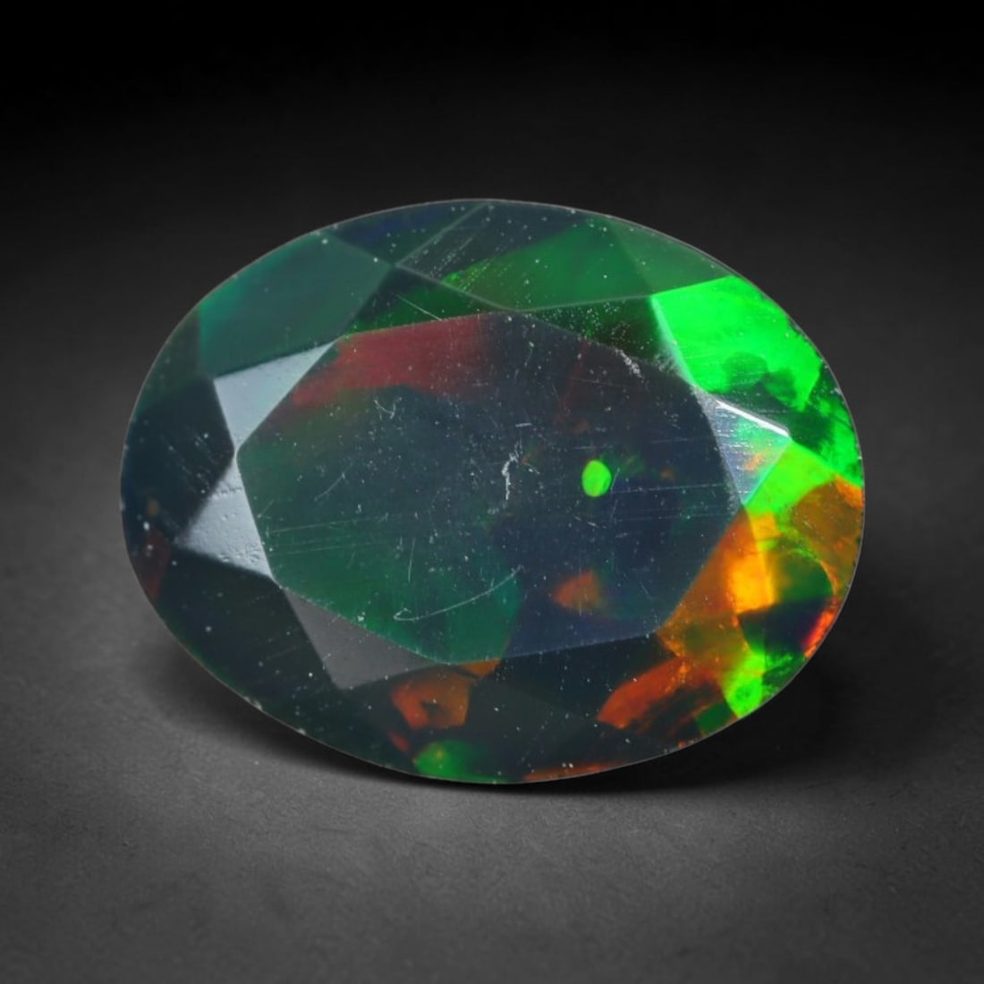 1.59ct Natural Ethiopian Welo Black Smoked Faceted Opal, 16EB, 16EB: This fully faceted finished opal specimen displays vivid shifting play of color across polished geometric facets within its 9.7x7.6x5.5mm calibrated dimensions, the dark base body amplifies light move
